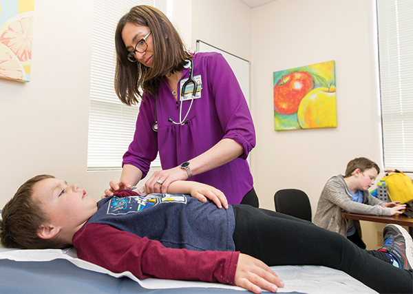 doctor examines a child with diabetes