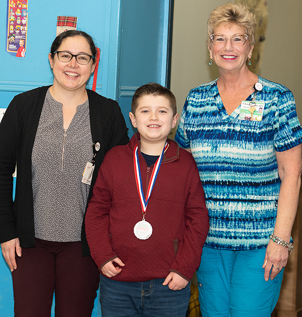 Cullen poses with his mom and one of his caregivers