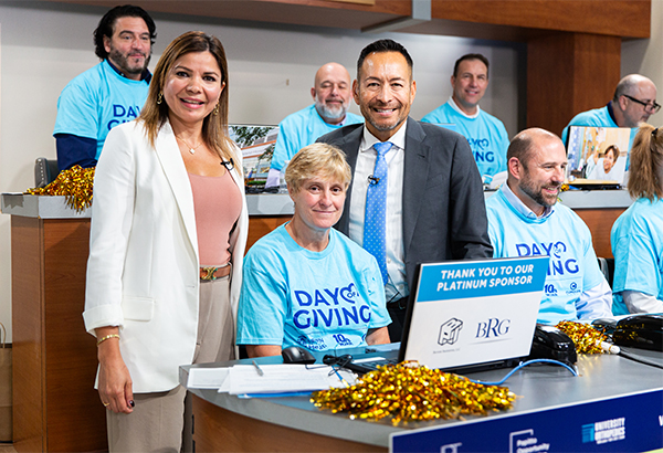 grateful patient stands with Mario Hilario and phone bank staff