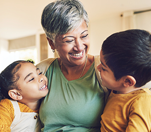 grandmother smiling down at two grandchildren